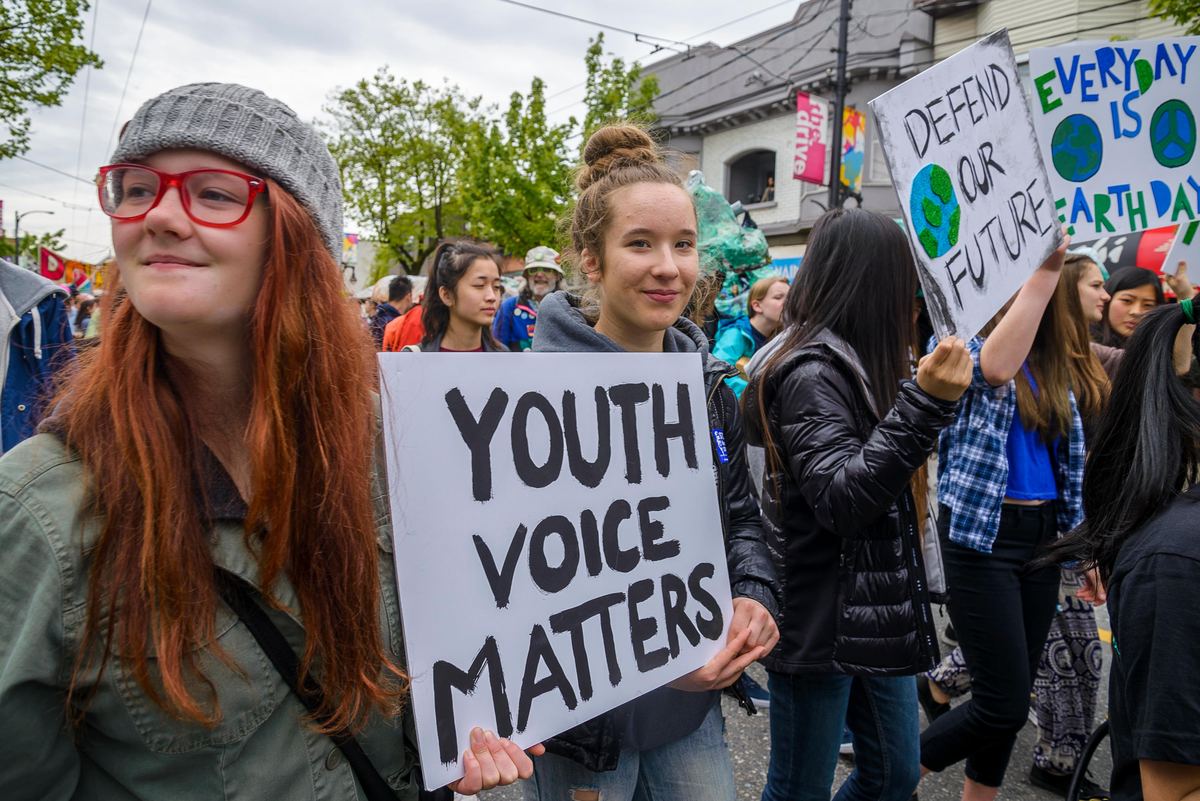 A young person at a march holding a sign that reads Youth voice matters